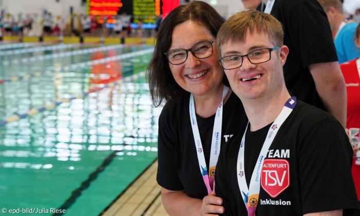 Eine Frau und ein Mann am Rande eines Schwimmbeckens