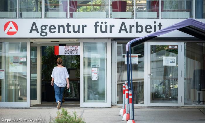 Eine verglaste Fassage, eine Frau geht durch die Tür