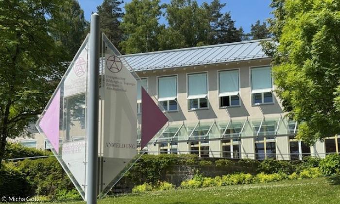Wegweiser vor einem Haus im Grünen
