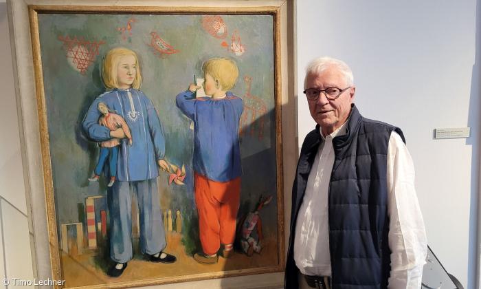 Peter Griebel vor einem Bildnis seines Vaters, das ihn als Kind mit seiner Schwester zeigt.