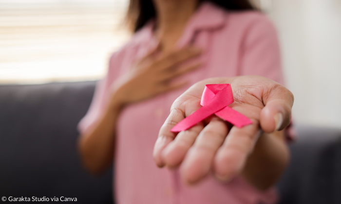 Frau hält rosa Schleife in der Hand