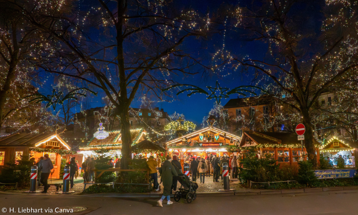 Am Abend mit hellen Lichtern der Haidhausener Weihnachtsmarkt mit Blick von der Straße