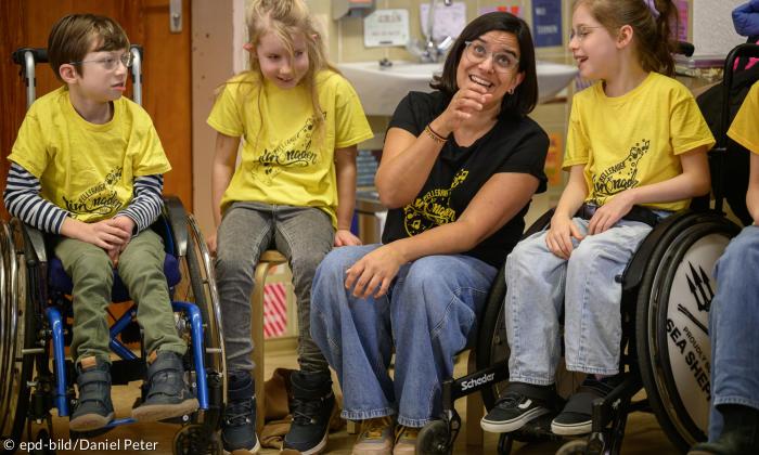 Saro Gerson leitet den Chor an diesem Tag, neben ihr Kinder, darunter zwei im Rollstuhl
