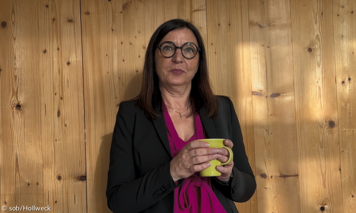 Eine Frau vor einer Holzwand