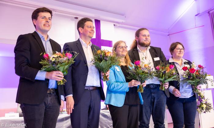 Fünf Menschen mit Blumensträußen 