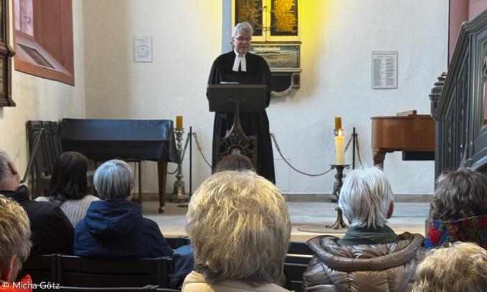 Ein Pfarrer steht vor der Gemeinde