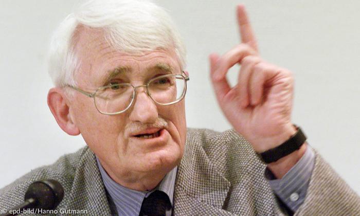 Ein Mann mit Brille, den Zeigefinger erhoben