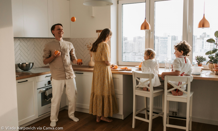 Eine Familie in der Küche, der Vater jongliert mit Orangen