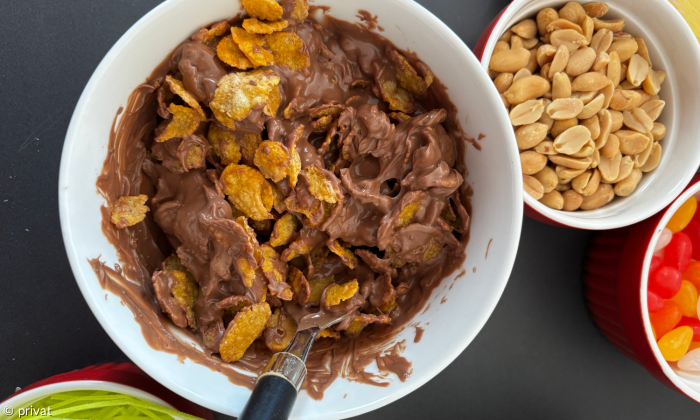 Schokolade mit Cornflakes in Schüssel und andere Zutaten drum herum