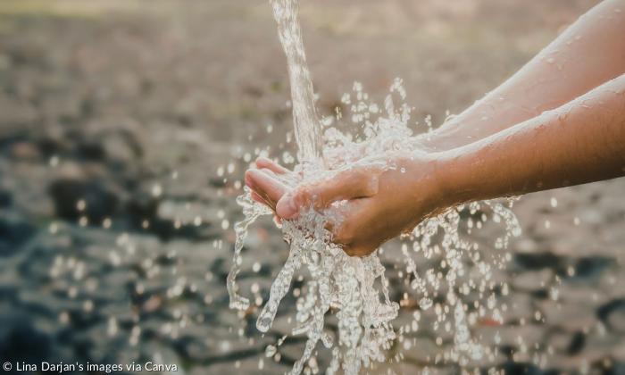 Zwei Hände fangen klares, spritzendes Wasser auf