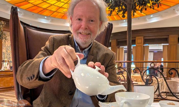 Ein Mann gießt Tee in eine Tasse