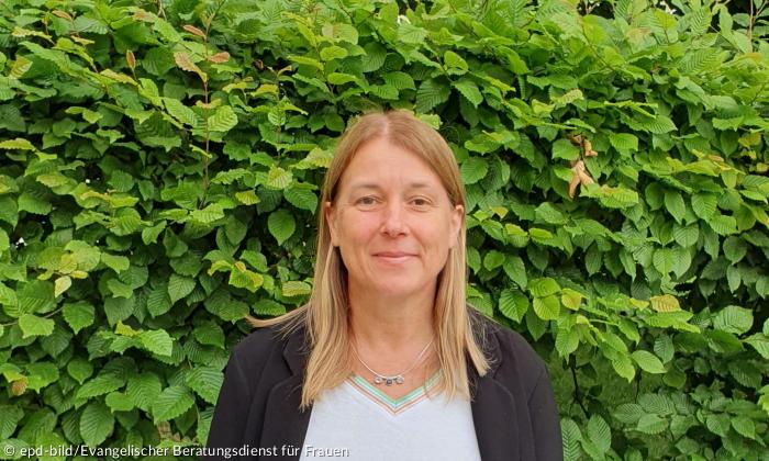 Eine Frau vor grünen Blättern
