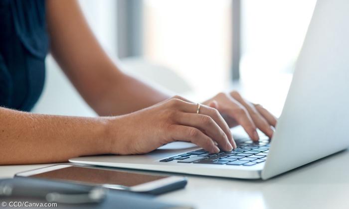 Hände tippen an einem Laptop