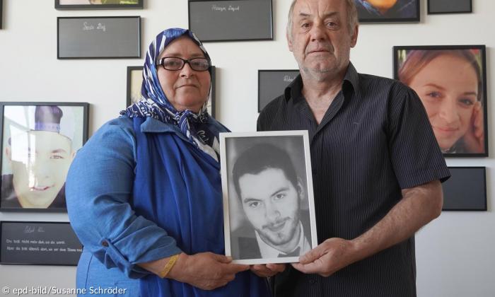 Eine Frau und ein Mann halten das Bild eines Jungen