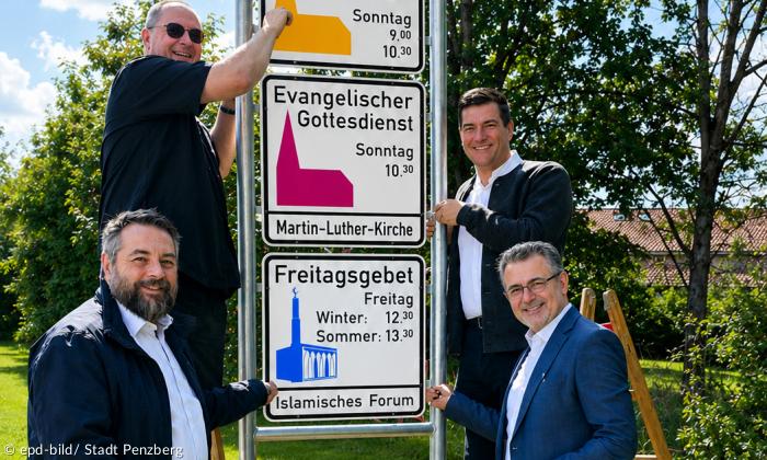 Vier Männer und drei Schilder