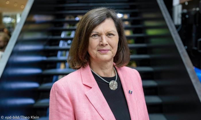 eine Frau im hellroten Blazer