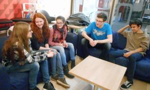 Jugendliche sitzen auf zwei Sofas