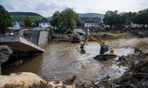 Ein Bagger steht im Wasser, daneben eine eingestürzte Brücke