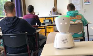 Schüler sitzen in der Schule und ein Roboter hilft. 
