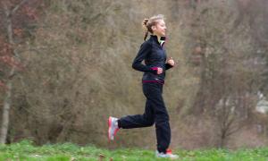 Eine Joggerin läuft über eine Wiese