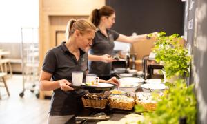 Tetiana und Viktoria (v.l.) aus Odessa bereiten das Frühstück in einem Hotel in München vor.
