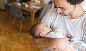 Ein Mann hält ein Baby auf dem Arm