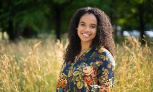 Eine junge schwarze Frau steht auf einem Feld
