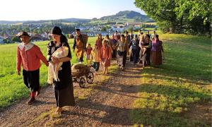 Menschengruppe läuft Feldweg entlang 