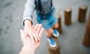 Kind hält Hand von Erwachsenden 
