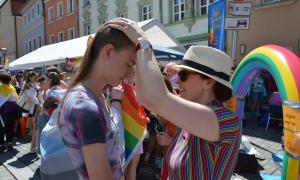Eine Frau legt die Hände auf den Kopf einer anderen Person