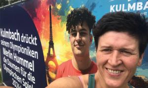 Eine Frau steht vor einem Plakat, das einen jungen Mann zeigt