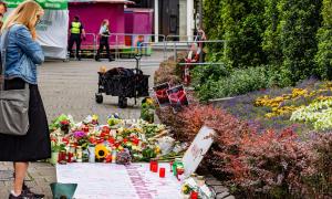 Eine Frau steht vor Kerzen und Blumen