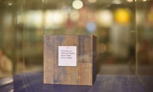 Eine Vitrine, in der ein Holzblock steht, darauf ein Schild, auf dem "Wir haben uns entschieden, dieses Objekt nicht zu zeigen" steht