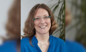 Eine Frau mit Brille, sie lächelt