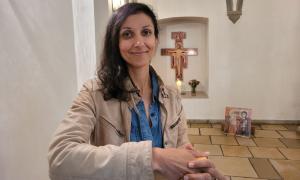 Eine Frau lächelt in einer Kirche in die Kamera