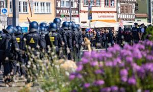 Mehrere schwarzgekleidete behelmte Polizisten bei einer Demonstration