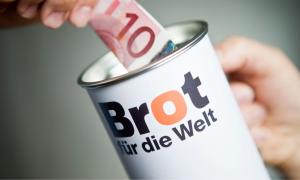 Eine Spendendose mit der Aufschrift "Brot für die Welt" und ein 10 Euro Schein