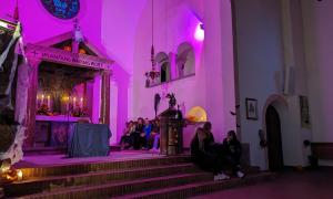 Eine Kirche mit dem Altar, in düster-lila Licht