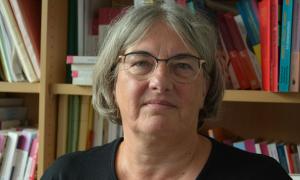 Eine Frau mit kurzen grauen Haaren und Brille