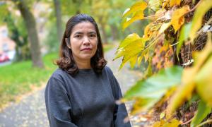 Eine Frau im dunklen Pulli vor Herbstblättern