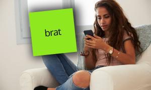 Eine Frau sitzt mit Smartphone in der Hand auf einem Sessel