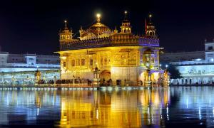 Ein goldener Tempel welcher in der Nacht beleuchtet wird
