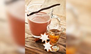 Ein Glas mit Kakao, eines mit Rum auf einem Tisch