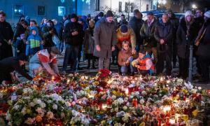 Menschen vor vielen Blumen und Kerzen
