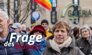 Menschen bei einer Demonstration mit einer Regenbogenfahne