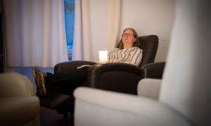 Eine Frau lehnt sich erschöpft in einen Sessel zurück