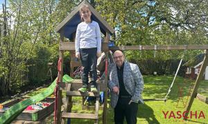Ein Junge und ein Mann im Garten, an einer Schaukel