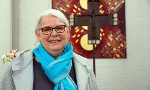 Eine Frau vor einem Kreuz
