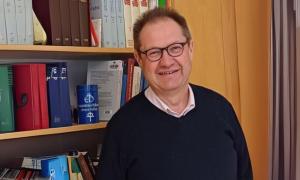 Ein Mann steht vor einem Bücherregal