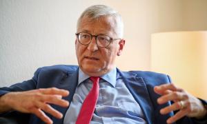 Ein Mann mit Brille und roter Krawatte spricht gestikulierend